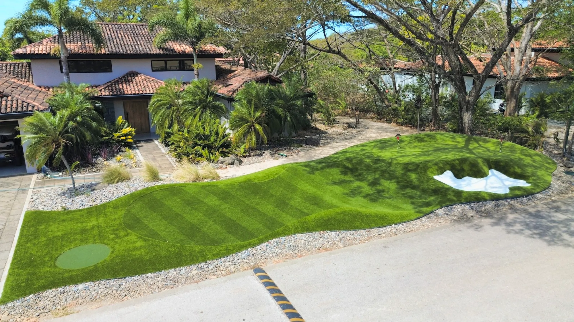 A striped putting green with a bunker running the length of a front garden