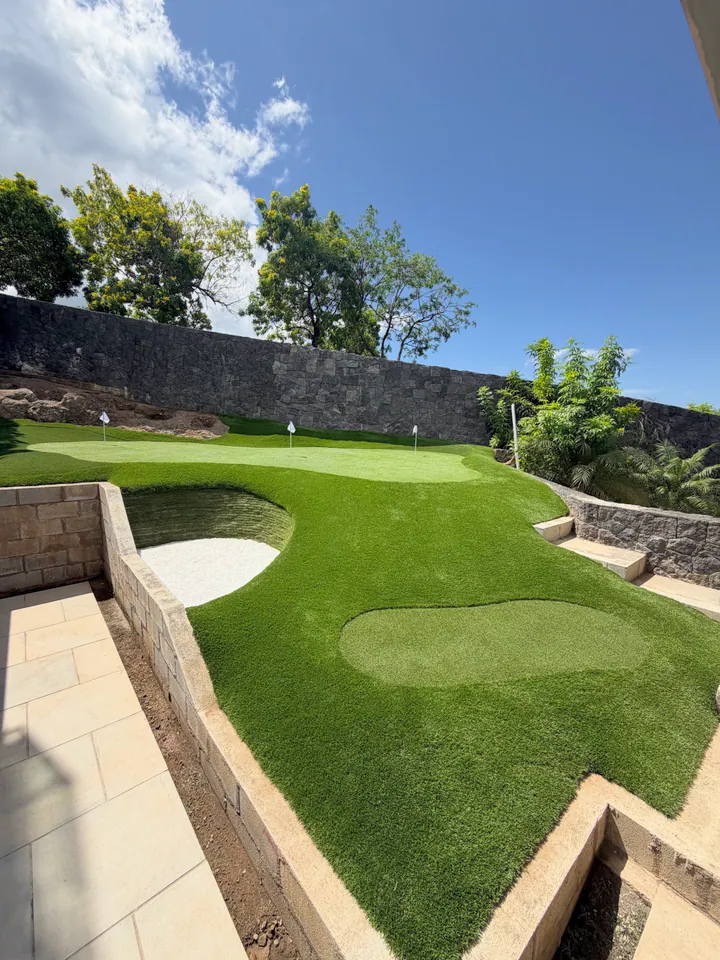 Multi-level backyard putting green with real sand bunker.