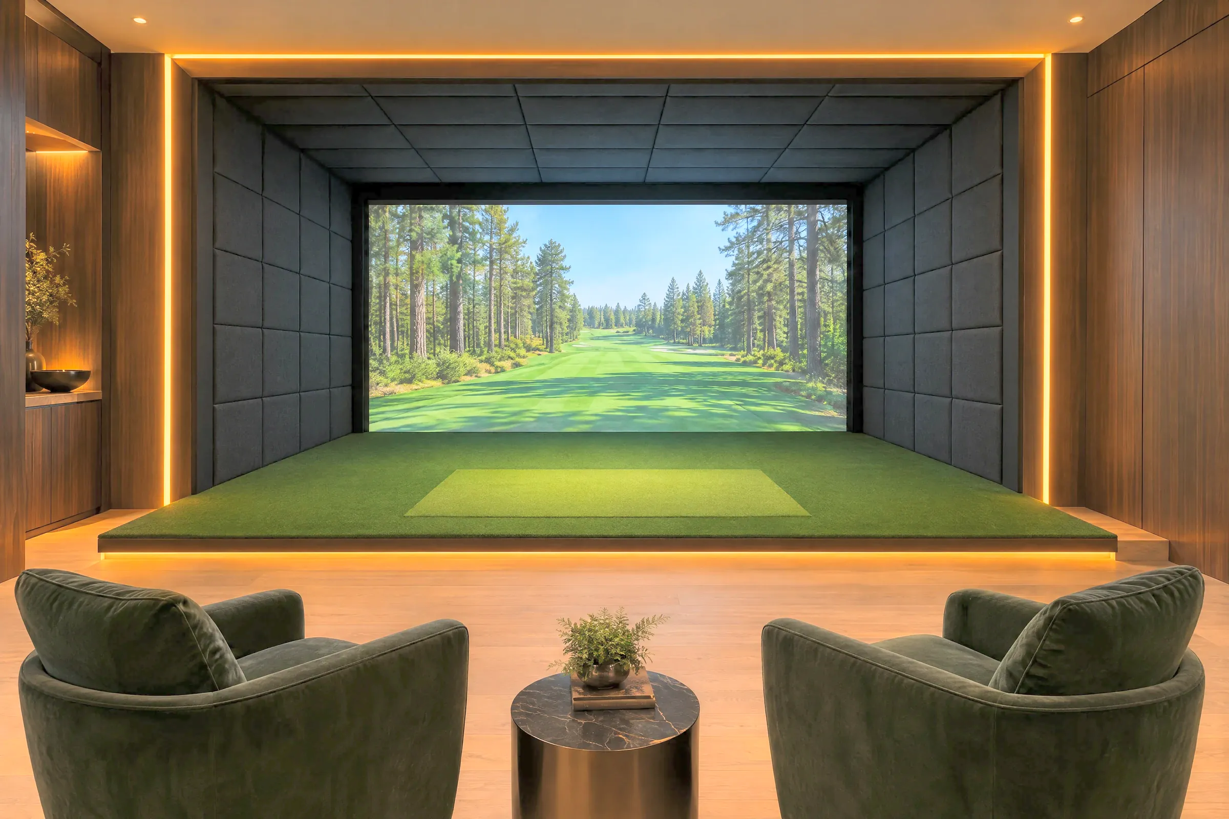 A golf simulator suite outlined in warm LED strip lighting, with a raised turf platform and two velvet armchairs